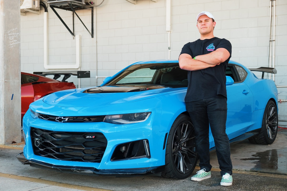 Man standing next to a Camaro ZL1.